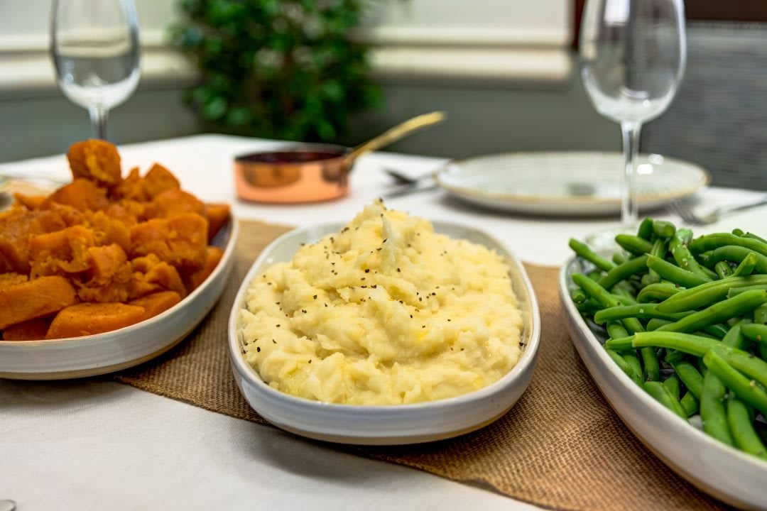 A delicious meal featuring mashed potatoes, green beans, and chicken wings ready to be served.