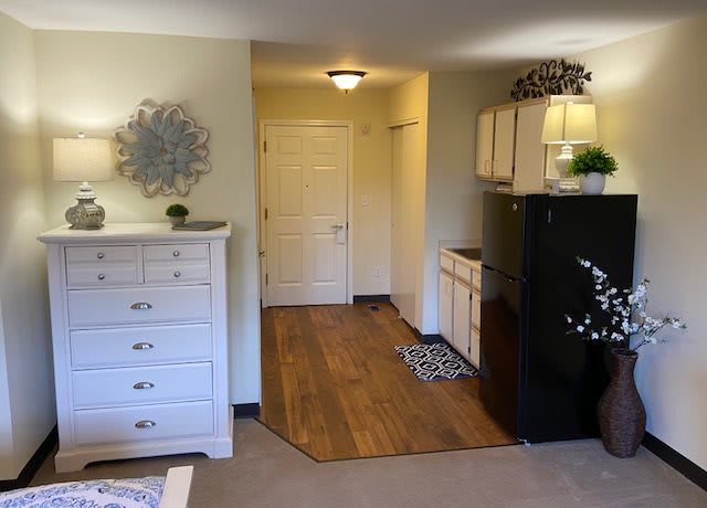 A cozy apartment kitchenette with light-colored furniture and modern decor.
