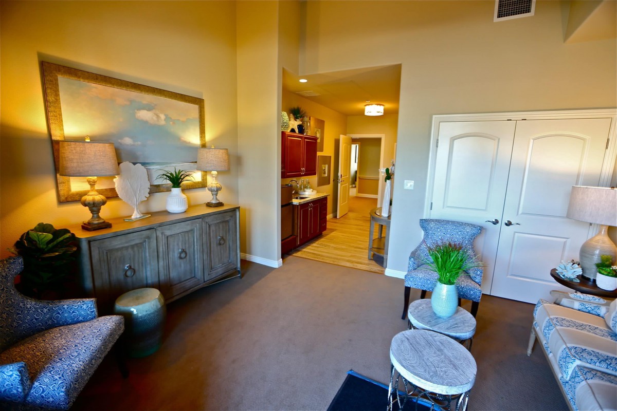 A stylish and modern living room with elegant decor, featuring a seating area, decorative plants, and ambient lighting.