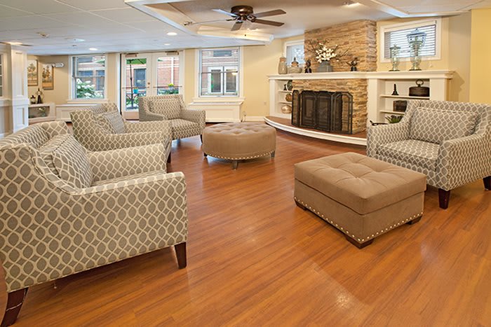 A cozy living room featuring multiple armchairs, a fireplace, and wood flooring.