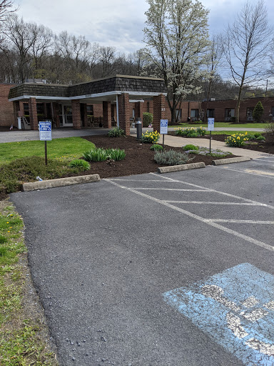 A view of a well-maintained building with a parking lot and landscaped garden.