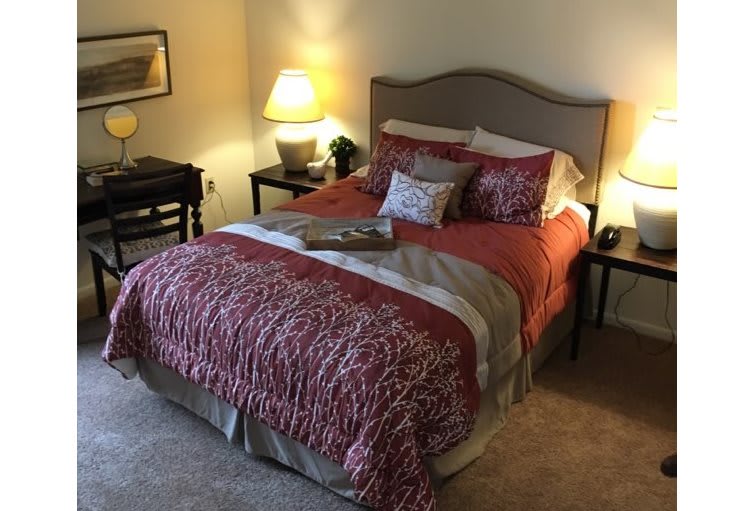 A cozy bedroom with a neatly made bed and soft lighting.