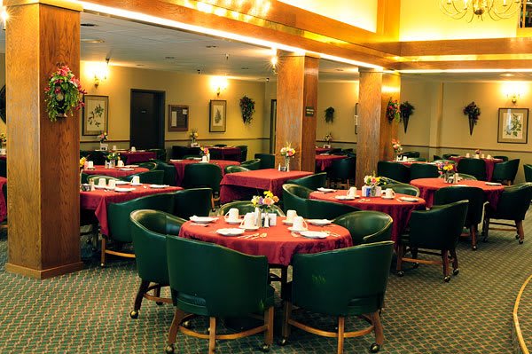 A cozy and elegant indoor restaurant dining area with neatly arranged tables and chairs.