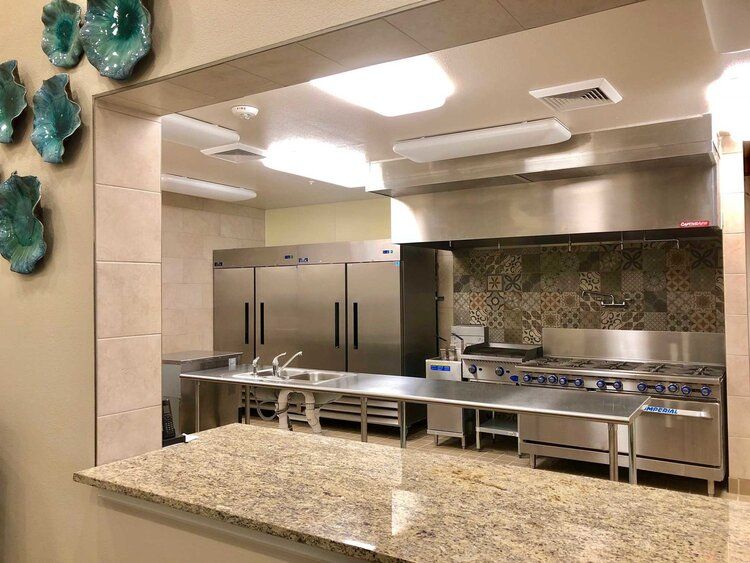 A view of a clean, well-equipped commercial kitchen with stainless steel appliances and ample countertop space.