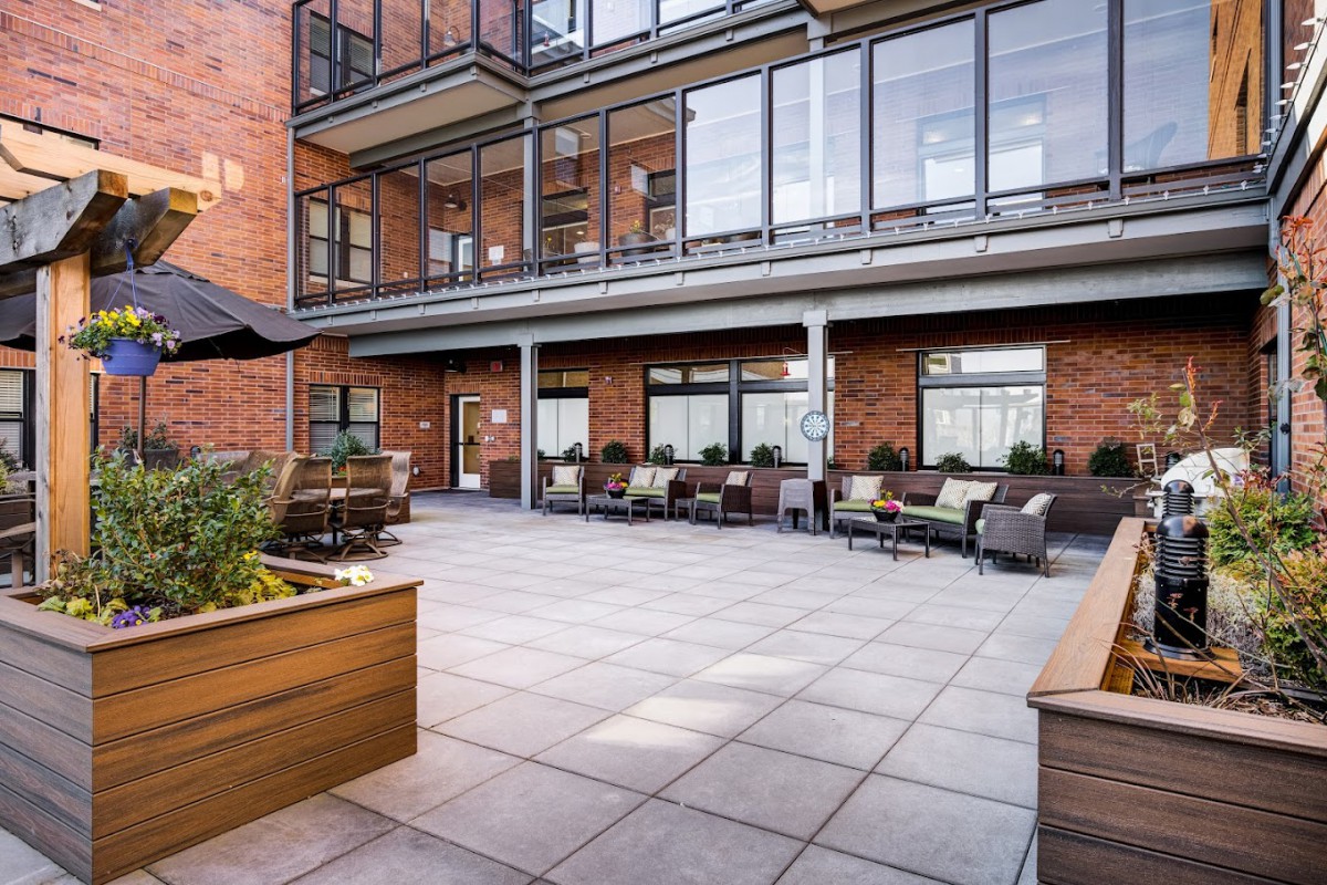 A modern outdoor patio area with comfortable seating at an apartment complex.