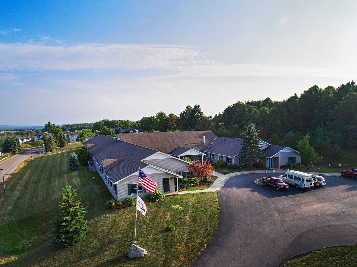 Aerial view of a nursing home with surrounding greenery and driveway entrance.