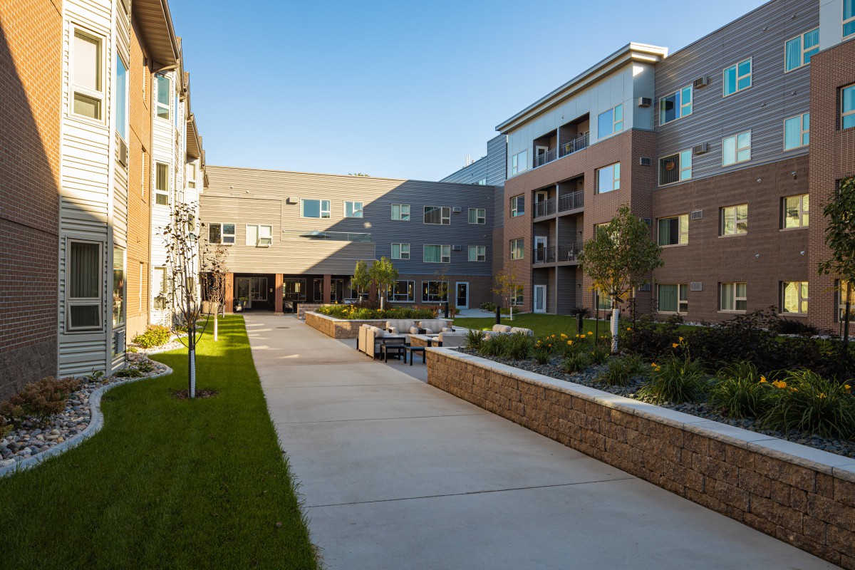 A modern apartment complex with a well-maintained courtyard and landscaping.