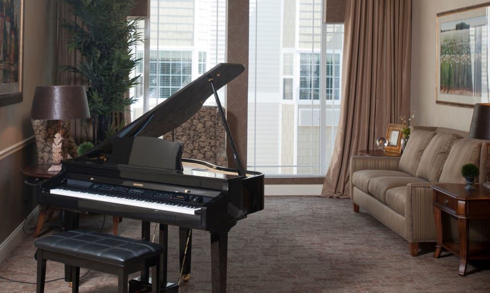 A cozy living room featuring a grand piano and comfortable seating.