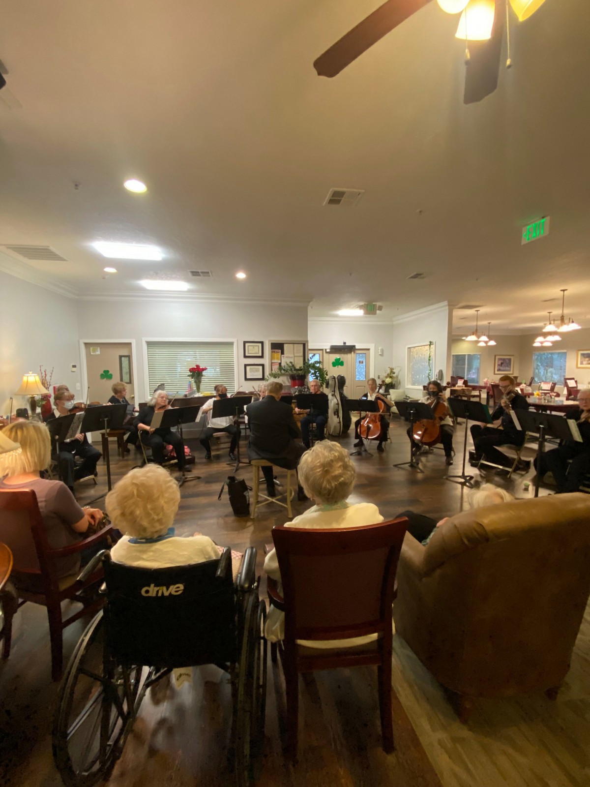A group of seniors seated in a circle for a community gathering indoors.