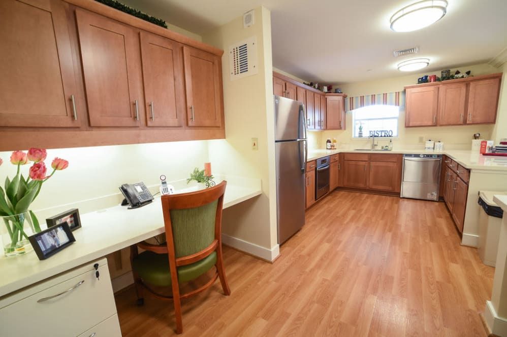 A spacious kitchen with wooden cabinets, a desk area, and stainless steel appliances.