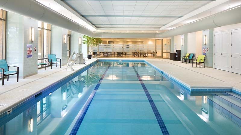 A modern indoor swimming pool with a relaxation area.