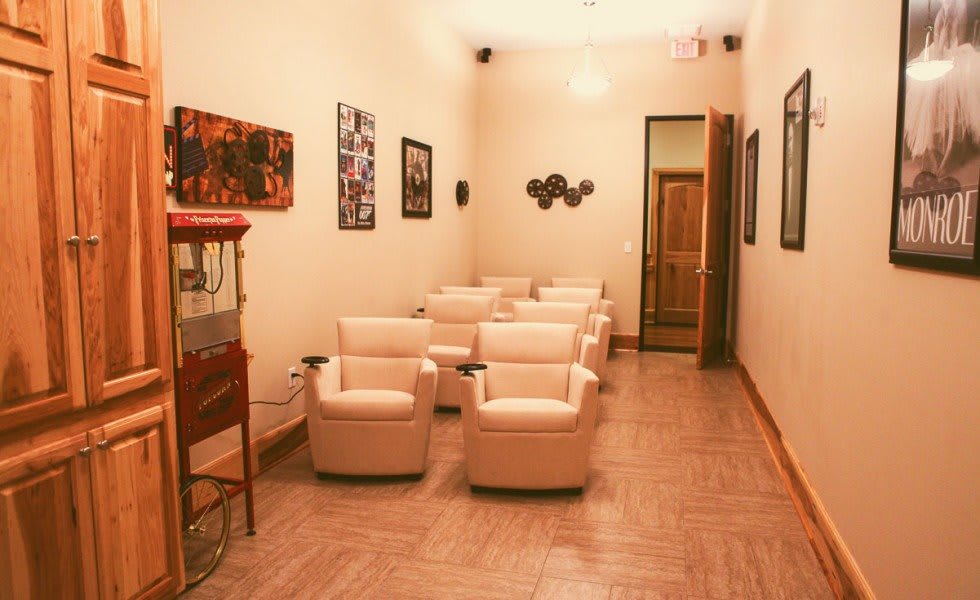 A cozy home theater room with comfortable seating and a popcorn machine.