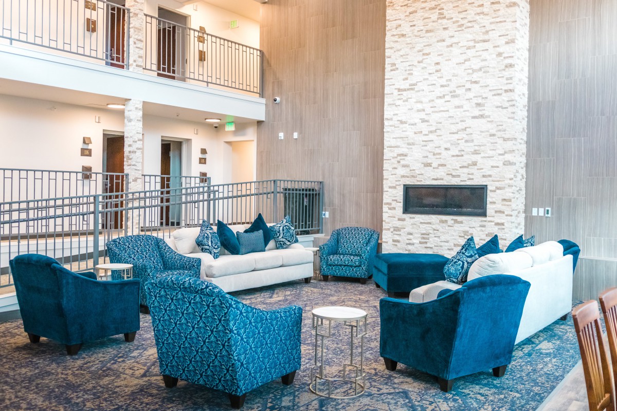 A stylish and modern lounge area featuring blue upholstered seating and a fireplace.