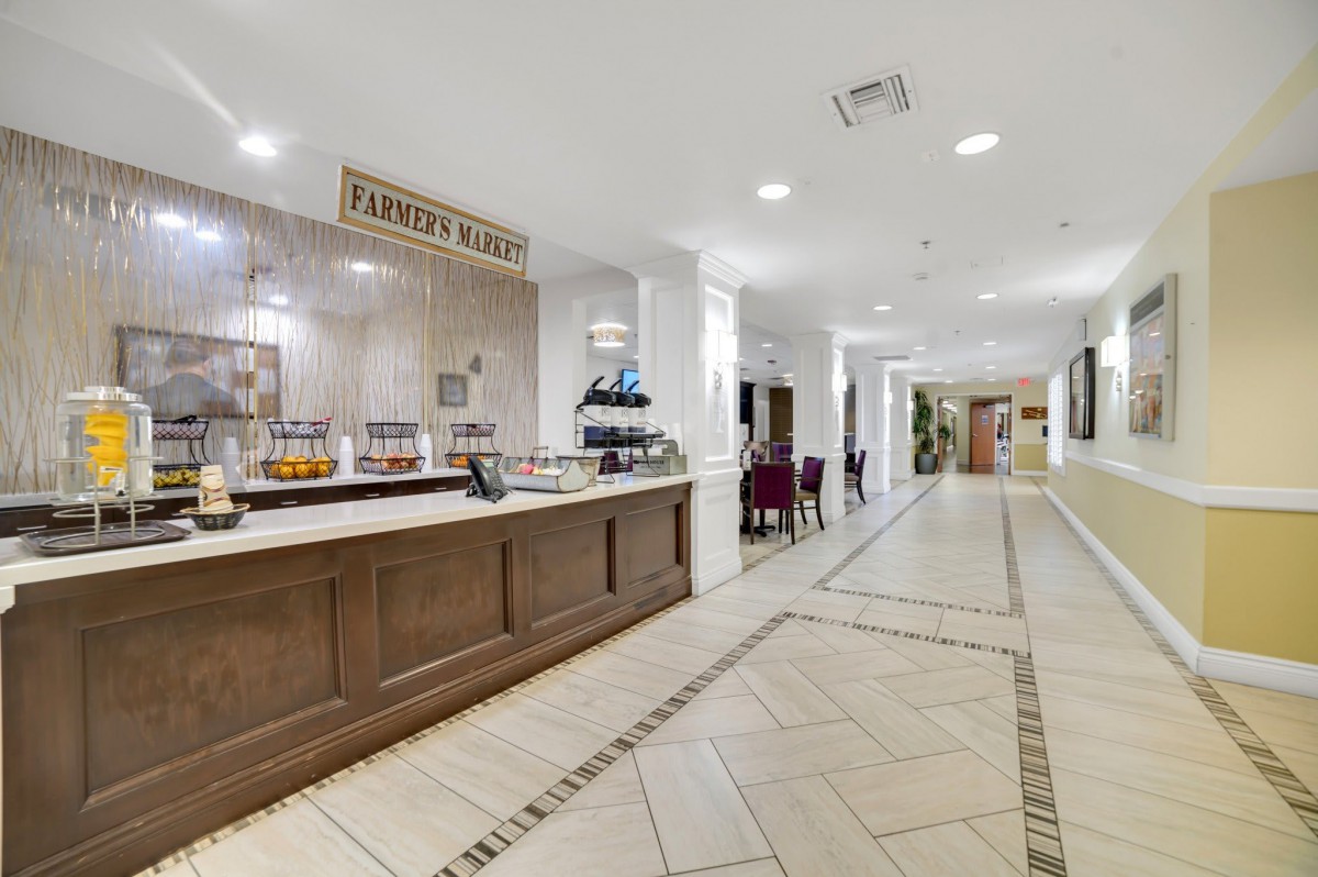 A hotel breakfast area featuring a buffet counter and dining tables.