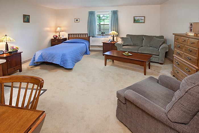 A cozy bedroom with a bed, sofa, and coffee table, decorated in a simple style.