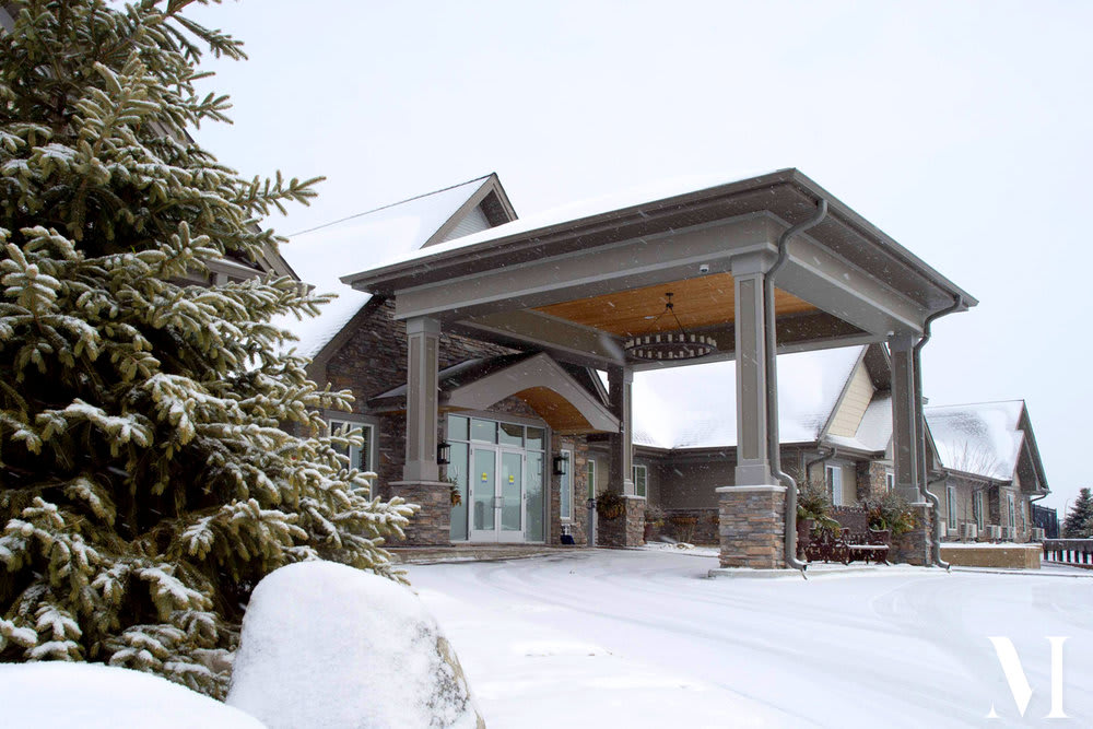 A house with a covered entryway blanketed in snow during winter.