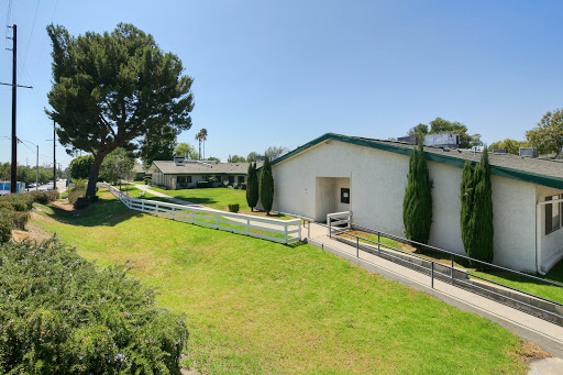 A serene view of a building surrounded by greenery and well-maintained pathways.