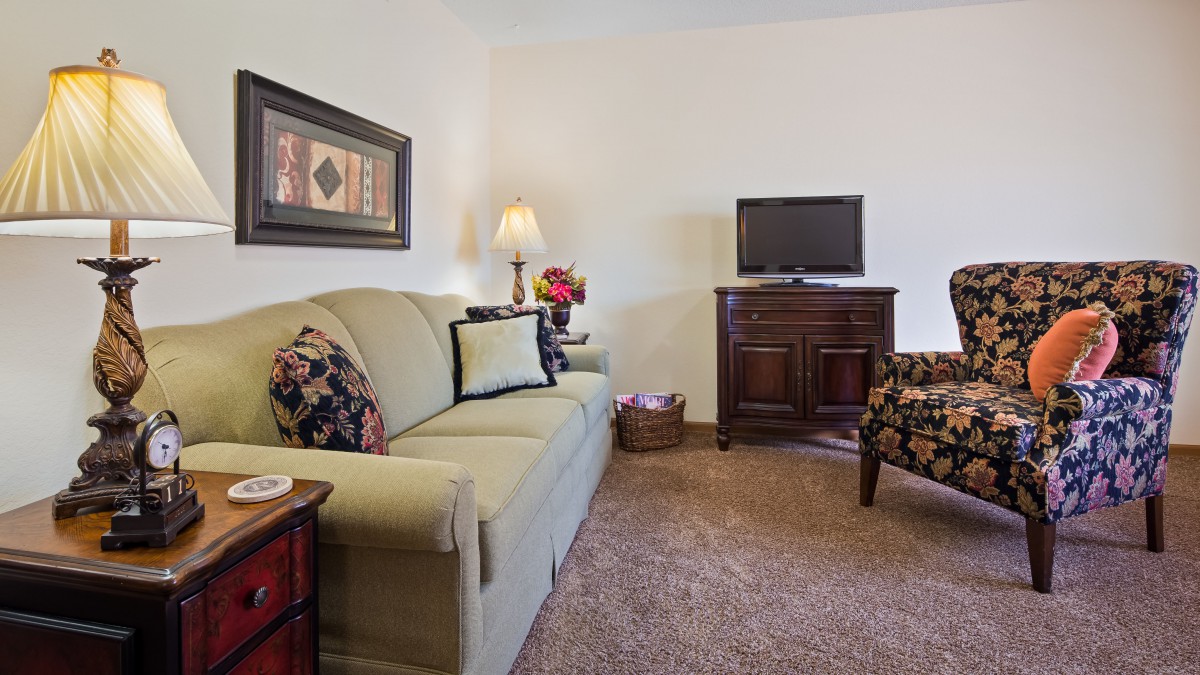 A cozy living room with a sofa, TV, and decorative elements.
