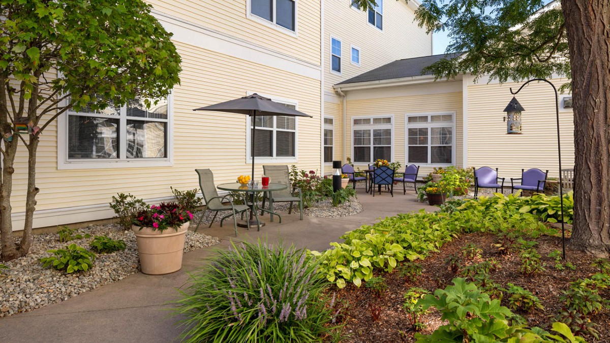 A cozy patio area with outdoor seating and a lush garden.