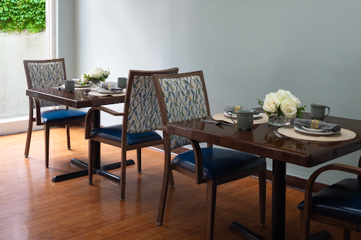 A stylish dining area featuring elegant tables and chairs, complemented by floral arrangements.