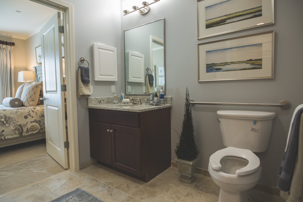 A modern bathroom with a sink, mirror, and toilet.