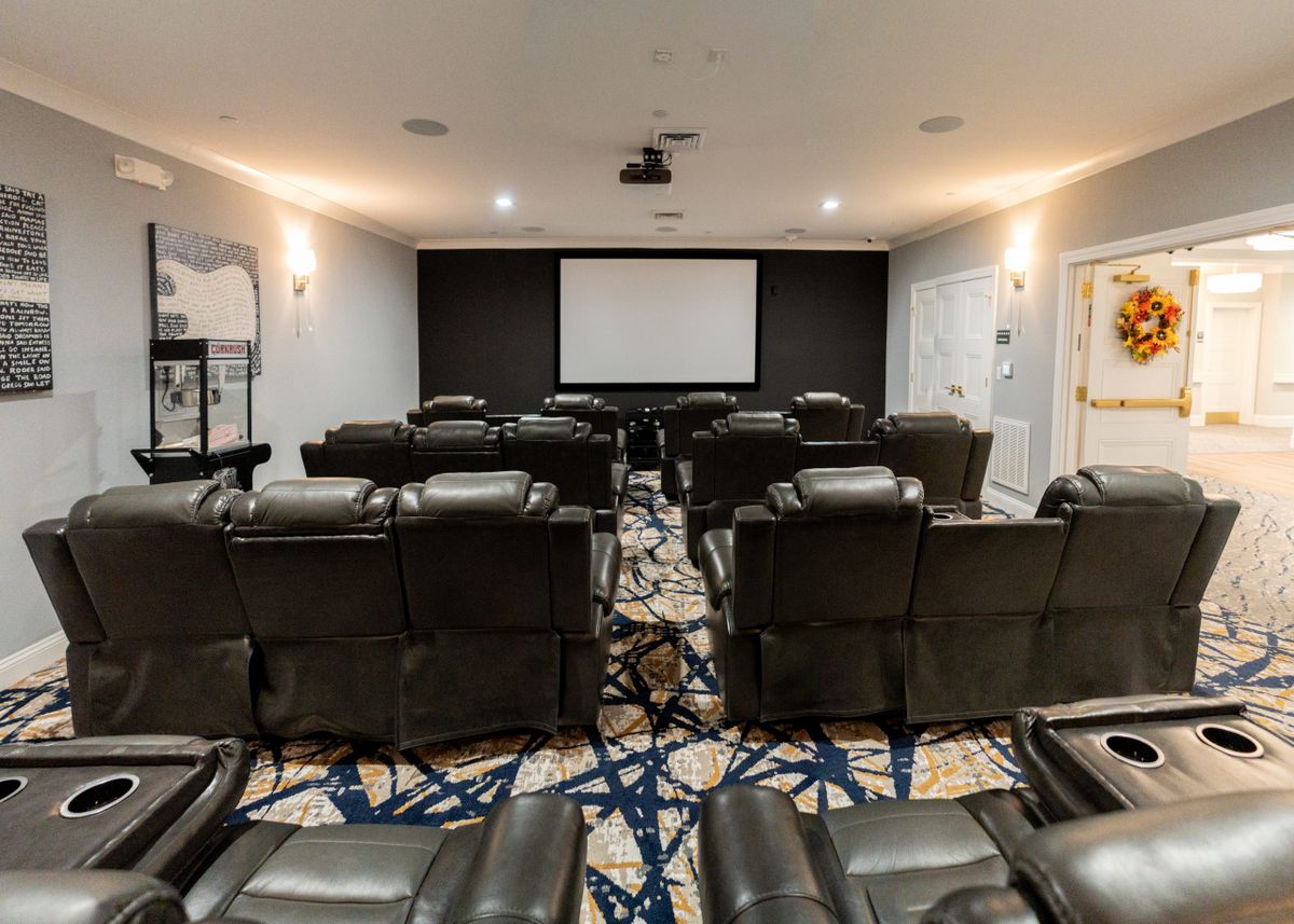A cozy home theater with leather recliners and a large projector screen.