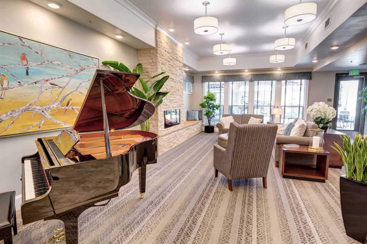 A modern lobby with a grand piano and a comfortable seating area.