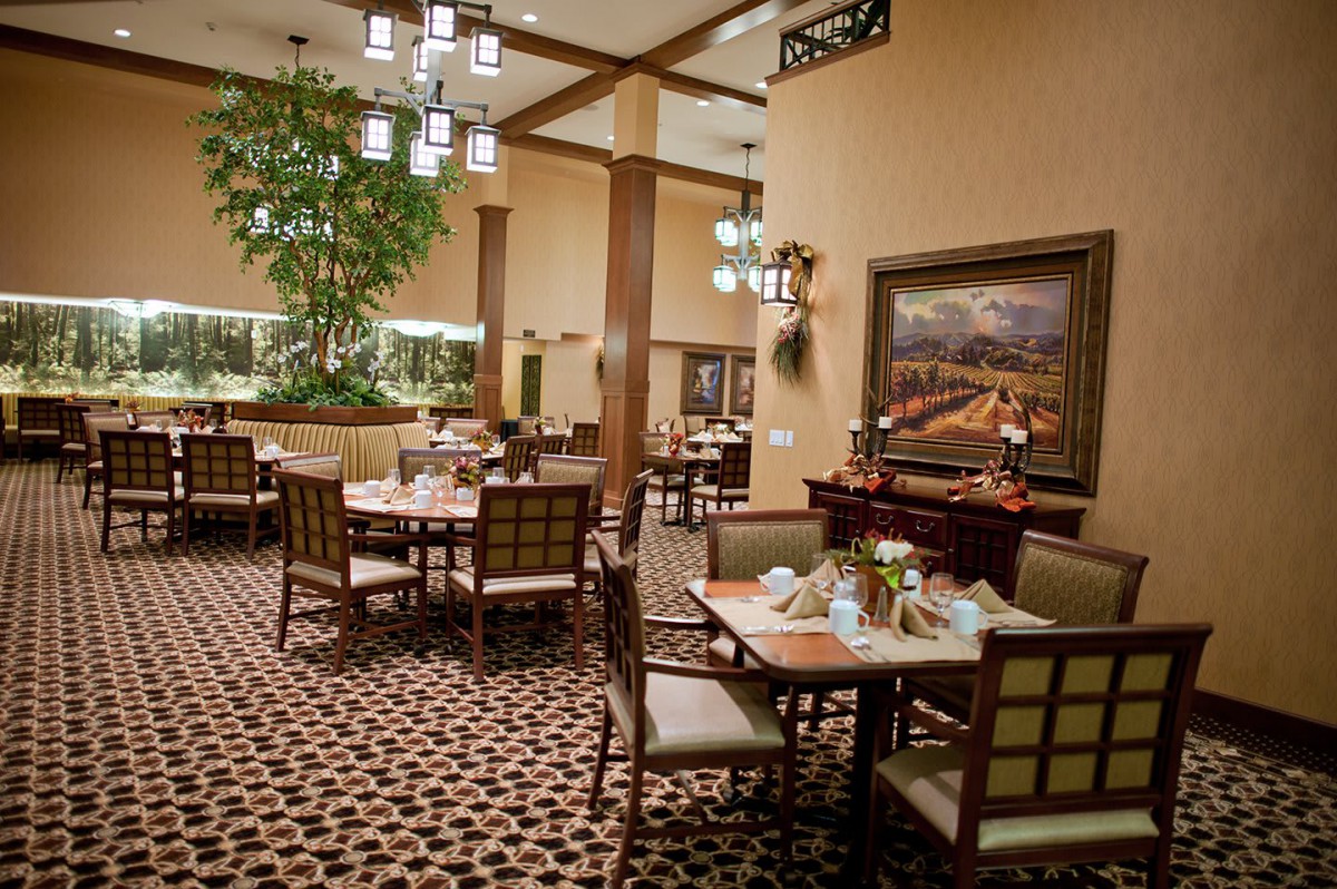 A well-decorated restaurant dining area with neatly arranged tables and elegant lighting.
