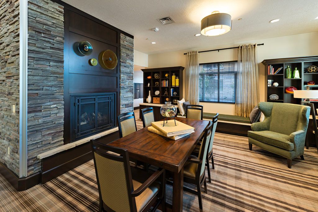 A modern dining room with a wooden table, comfortable chairs, and a stylish fireplace.