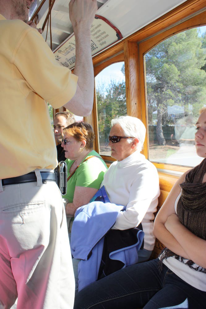 Passengers seated inside a sunlit public transport vehicle.