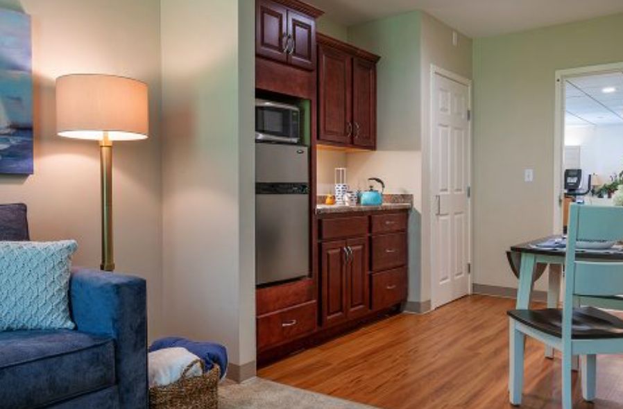 A cozy kitchen with wooden cabinets, modern appliances, and warm lighting.