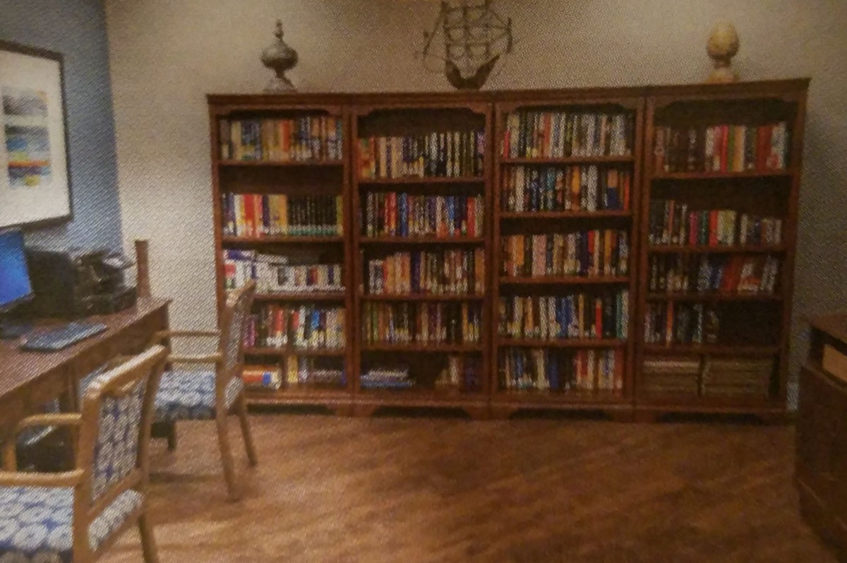 A cozy library room with wooden bookshelves filled with books.