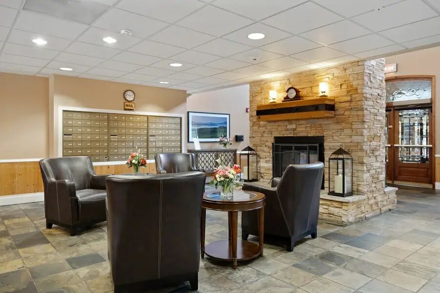 A cozy lobby interior featuring a fireplace, comfortable seating, and elegant decor.