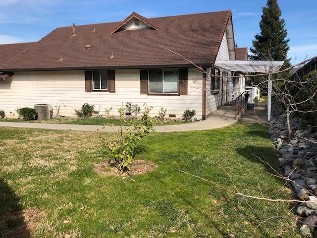 A residential house with a grassy yard and small garden.