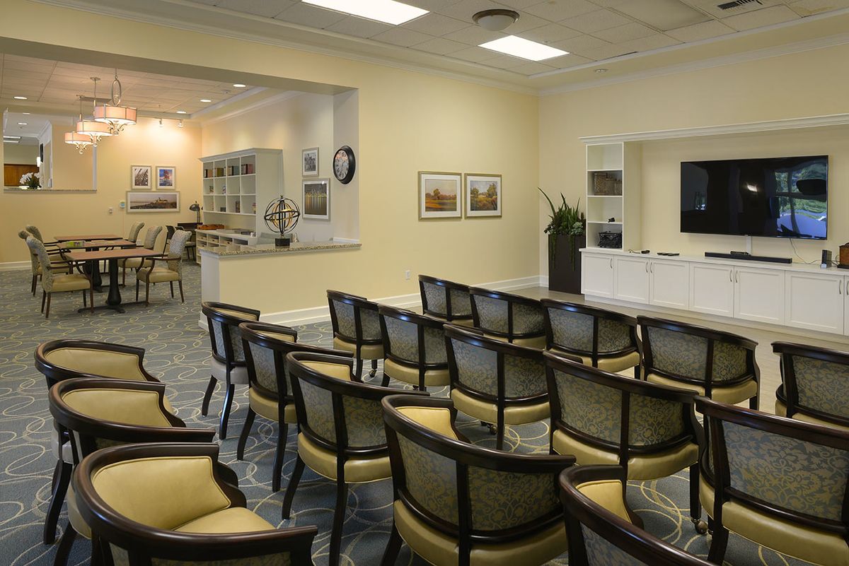 A neatly arranged conference room with rows of chairs facing a television, ready for a meeting or presentation.