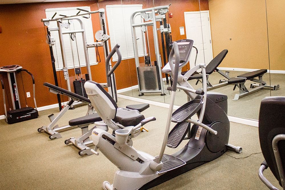 A well-equipped gym room featuring various exercise machines.