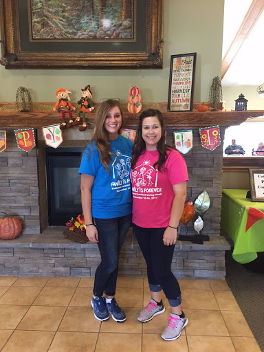 Two friends posing together in colorful shirts at a festive gathering.