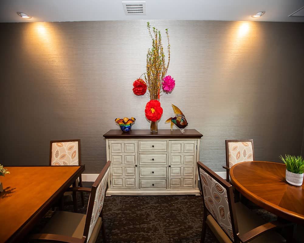 A modern dining room with minimalist decor and vibrant floral arrangements.