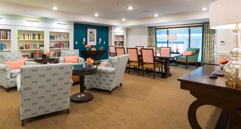 A cozy lounge area with comfortable seating, bookshelves, and tables for relaxation.