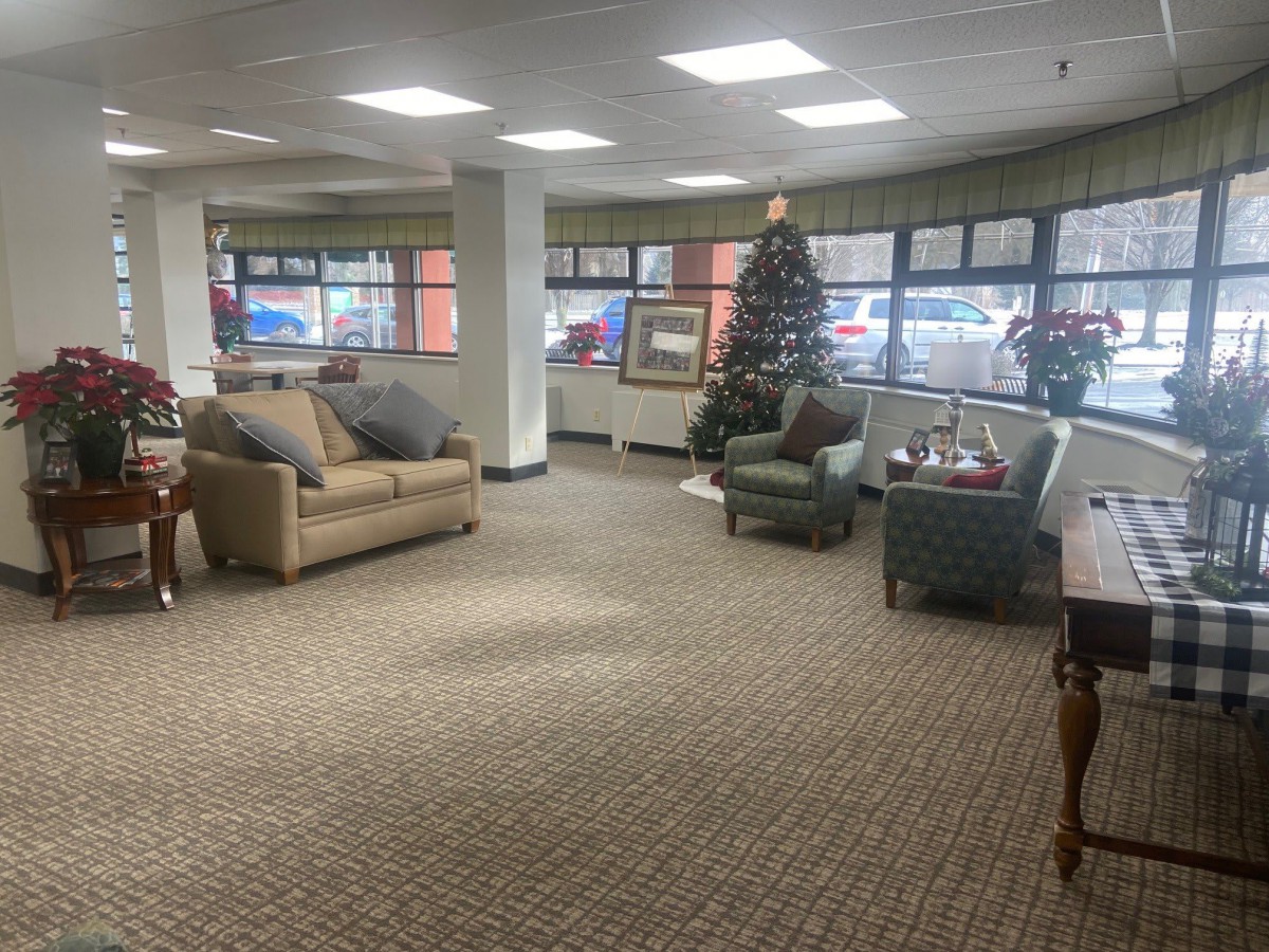 A cozy lobby area decorated with a Christmas tree, featuring sofas and armchairs.