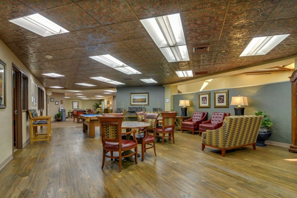 A spacious and well-lit lounge area with various seating arrangements and decorative art on the walls.