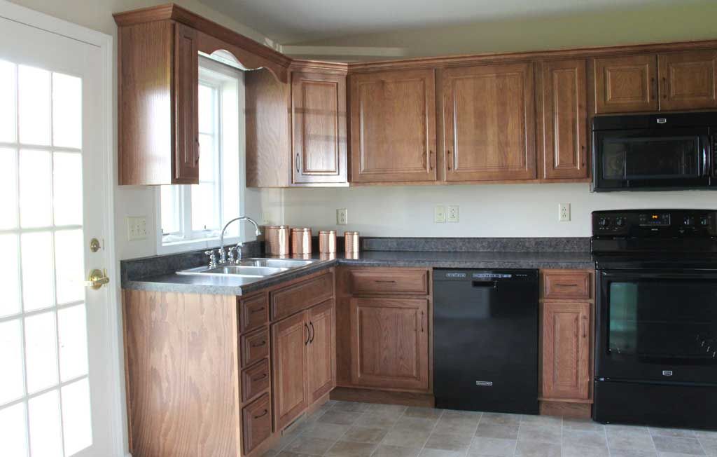 A modern kitchen with wooden cabinets and a black dishwasher.