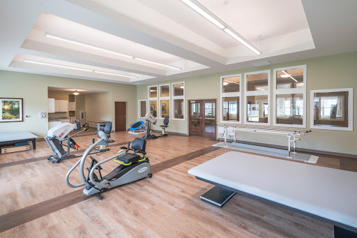 A well-equipped fitness center featuring various exercise machines and a spacious training area.