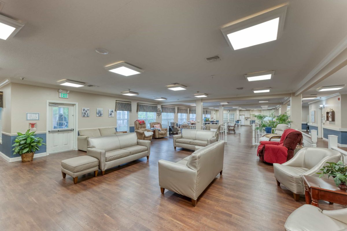 A spacious and well-lit lounge area with comfortable sofas and wooden flooring.