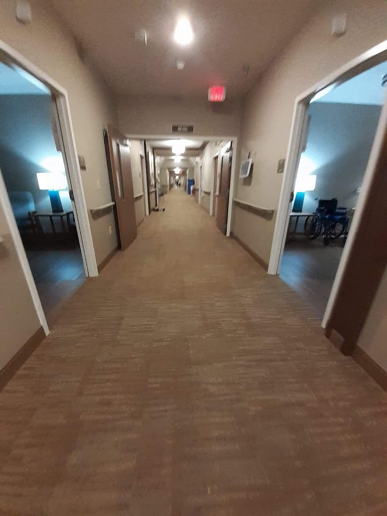A well-lit hallway with open doors on either side.