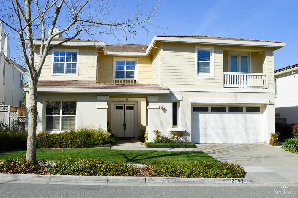 A two-story suburban house with a garage and landscaped front yard.