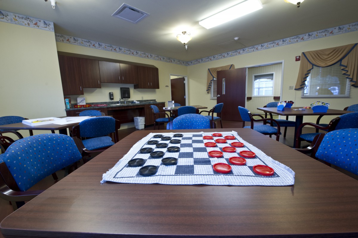 A cozy game room with a checkers board set up on the table.