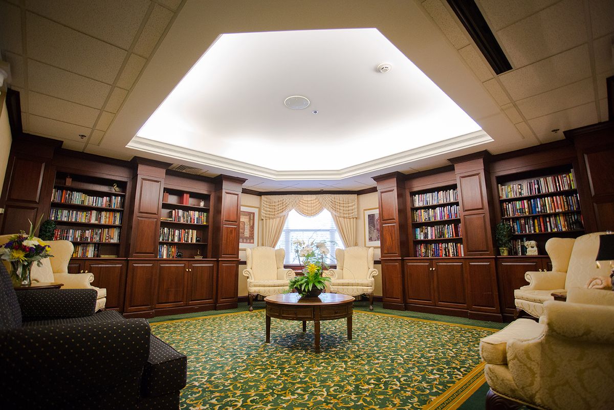 A cozy library interior with wooden bookshelves and a central reading area.