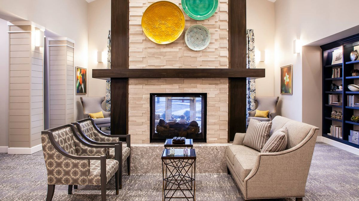 A modern and cozy living room with a central fireplace and comfortable seating.