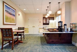 A cozy dining area with a kitchen counter and coffee machine, featuring warm lighting and comfortable seating.